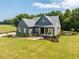 Stunning exterior of a modern farmhouse-style home with lush landscaping at 223 Lindo Johnson Rd, Pittsboro, NC 27312