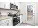 Kitchen featuring stainless steel appliances, granite countertops, and stylish white cabinetry at 228 Moyer Dr, Graham, NC 27253