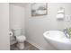 Neutral powder room with sleek pedestal sink, gray wood floors and subtle artwork at 232 Moyer Dr, Graham, NC 27253