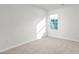 Bright bedroom with neutral carpet, white walls, and a window providing natural light at 236 Moyer Dr, Graham, NC 27253