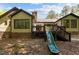 View of the backyard featuring an outdoor deck with a slide, as well as a brick chimney at 237 Jason Way, Youngsville, NC 27596