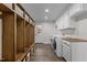 Mudroom with coat racks and overhead storage located next to the laundry room with modern machines at 237 Jason Way, Youngsville, NC 27596