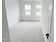 Bright bedroom featuring two windows and neutral carpeting, offering a clean and modern feel at 2403 Whitewing Ln, Wendell, NC 27591