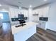 Modern kitchen with white cabinets, stainless steel appliances, and center island with sink at 2403 Whitewing Ln, Wendell, NC 27591