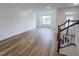 Bright living room with wood floors, natural light, and staircase at 2403 Whitewing Ln, Wendell, NC 27591