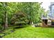 Lush green backyard featuring a shed, fire pit, mature trees and landscaping at 244 Mantle Dr, Clayton, NC 27527
