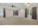 Bright, carpeted bedroom with tray ceiling, fan, and natural light from three windows at 244 Mantle Dr, Clayton, NC 27527