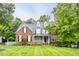 Charming brick two-story home featuring a well-manicured lawn, dormers, and a welcoming front porch at 244 Mantle Dr, Clayton, NC 27527