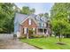 Charming brick two-story home featuring a well-manicured lawn, dormers, and a welcoming front porch at 244 Mantle Dr, Clayton, NC 27527