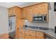 Basement kitchenette area with stainless appliances, granite countertops, and wood cabinets at 244 Mantle Dr, Clayton, NC 27527