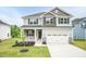Charming two-story home with gray siding, stone accents, a well-manicured lawn, and a two car garage at 263 Hopewell Branch Ct, Smithfield, NC 27577