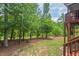 View of backyard with lush green trees, grass, and patio area at 2633 Beckwith Rd, Apex, NC 27523