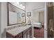 Bathroom featuring a granite countertop vanity, a sink, and artwork displayed on the wall at 2633 Beckwith Rd, Apex, NC 27523