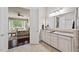Bathroom with double sink vanity and view into the bedroom with sitting area and large windows at 2633 Beckwith Rd, Apex, NC 27523