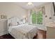 Well-lit bedroom features a decorative bed frame, wood floors, and a window overlooking greenery at 2633 Beckwith Rd, Apex, NC 27523