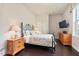 Bedroom with hardwood floors, a black metal bed frame, and wooden nightstands and dresser at 2633 Beckwith Rd, Apex, NC 27523