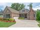 A stone and siding home boasts a two-car garage, covered entryway and well-maintained landscaping at 2633 Beckwith Rd, Apex, NC 27523