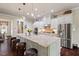 Well-appointed kitchen featuring an expansive island, stainless steel appliances, and beautiful white cabinetry at 2633 Beckwith Rd, Apex, NC 27523