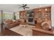 Cozy living area with leather sofas, a fireplace framed by built-in shelves, and hardwood floors at 2633 Beckwith Rd, Apex, NC 27523
