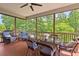 This screened porch features wicker seating, a ceiling fan, and a glass-topped table for outdoor dining at 2633 Beckwith Rd, Apex, NC 27523