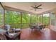 Relaxing screened porch features wicker seating, a ceiling fan, and picturesque views of the lush green backyard at 2633 Beckwith Rd, Apex, NC 27523