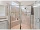 Close-up of the glass shower featuring tile surround, built-in bench, and shower niche at 2633 Beckwith Rd, Apex, NC 27523