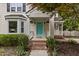 Charming front porch featuring brick steps, a bright teal door, and decorative hanging plants at 2705 Kempsford Pl, Raleigh, NC 27604