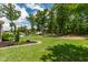 Spacious backyard offering a pool, green lawn, mature trees, and garden at 2912 Turning Brook Ln, Raleigh, NC 27616