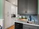 Stylish bar area featuring granite countertops, white cabinets, mosaic backsplash, and modern fixtures at 2912 Turning Brook Ln, Raleigh, NC 27616