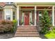 Charming brick home featuring a red front door, landscaping, and covered porch at 2912 Turning Brook Ln, Raleigh, NC 27616