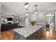 Open kitchen boasts granite counters, pendant lighting, and a seamless transition to the adjacent living and dining areas at 2912 Turning Brook Ln, Raleigh, NC 27616