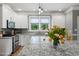 Bright kitchen featuring granite countertops, white cabinets, stainless steel appliances, and a view of the backyard at 2912 Turning Brook Ln, Raleigh, NC 27616
