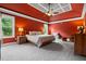 Spacious main bedroom with bright red walls, tray ceilings, and carpeted floors at 2912 Turning Brook Ln, Raleigh, NC 27616