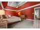 Main bedroom showcasing bold red walls, plush carpet, and a king bed with side tables at 2912 Turning Brook Ln, Raleigh, NC 27616