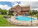 Backyard view of in-ground pool with tanning deck and patio area with pergola and screened porch at 2912 Turning Brook Ln, Raleigh, NC 27616