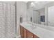 Bathroom features white quartz countertop, wood cabinets, single sink, and shower with patterned shower curtain at 303 Leighann Ridge Ln, Rolesville, NC 27571