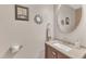 Half bathroom features a vanity with granite countertop and a round mirror at 303 Leighann Ridge Ln, Rolesville, NC 27571