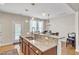 Open-concept kitchen with granite counters, stainless steel appliances, and a breakfast bar leading to outdoor access at 303 Leighann Ridge Ln, Rolesville, NC 27571