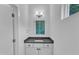 Powder room featuring modern vanity with a gray countertop, mirror, and stylish light fixture at 304 S Tarboro St, Raleigh, NC 27610
