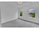 Bright bedroom with soft carpet, neutral walls, and windows with leafy views at 304 S Tarboro St, Raleigh, NC 27610