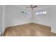 Minimalist bedroom with hardwood floors, two windows letting in natural light, and a modern ceiling fan at 304 S Tarboro St, Raleigh, NC 27610