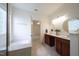 Bright bathroom featuring double sinks, a soaking tub, and neutral tile flooring at 306 Plank Bridge Way, Morrisville, NC 27560