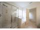 Bathroom featuring a glass-enclosed shower and a soaking tub under a window at 306 Plank Bridge Way, Morrisville, NC 27560