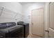A well-lit laundry room with a washer, dryer, and wire shelving at 306 Plank Bridge Way, Morrisville, NC 27560