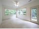 Bright, sunlit room with neutral tile flooring, a ceiling fan, and backyard access at 306 Plank Bridge Way, Morrisville, NC 27560