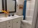Well-lit bathroom features a white vanity, framed mirror and a shower with a blue curtain at 31 Kevior Ave, Four Oaks, NC 27524