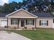 Charming single-story home with a well-manicured lawn and inviting front porch and long concrete driveway at 31 Kevior Ave, Four Oaks, NC 27524