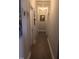Long hallway with neutral paint, white trim and doors, and framed decor at 31 Kevior Ave, Four Oaks, NC 27524