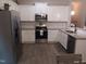 Bright kitchen featuring white cabinets, granite countertops, stainless steel appliances, and wood flooring at 31 Kevior Ave, Four Oaks, NC 27524