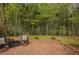 Brick patio with decorative brick wall and wrought-iron furniture in wooded backyard setting at 318 Tillamook Dr, Wake Forest, NC 27587